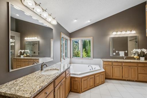 Primary bathroom with a jetted tub and two large vanities