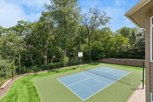 Sport court lined for pickleball and has a permanent basketball hoop