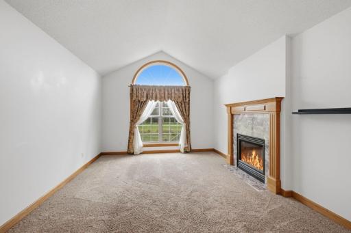 This bright living room boasts a huge window and gorgeous gas fireplace.