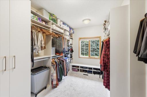 Primary custom walk-in closet shelving provides exceptional organization and storage.
