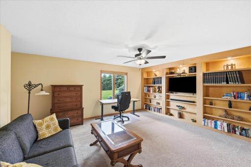 Additional bedroom with custom built-in shelving offers flexibility for work, hobbies, or guests.