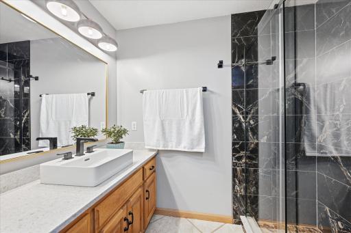 Updated lower-level bathroom showcases a beautifully tiled walk-in shower.