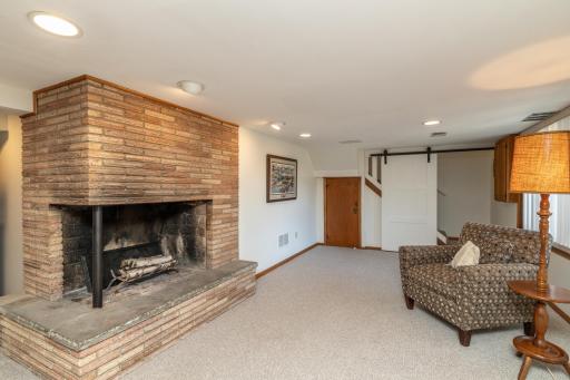 Lower Level Family Room Features Floor to Ceiling Brick Fireplace