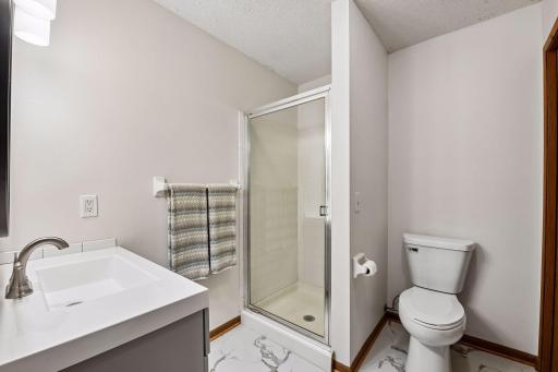 Lower level 3/4 bath with new flooring, toilet and vanity