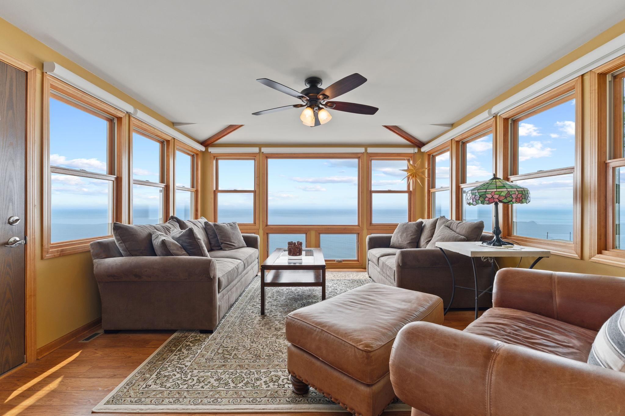 Surrounded by walls of windows, the four-season sunroom offers an immersive lakefront experience with spectacular 180° west-facing views and unforgettable sunsets over Lake Mille Lacs.