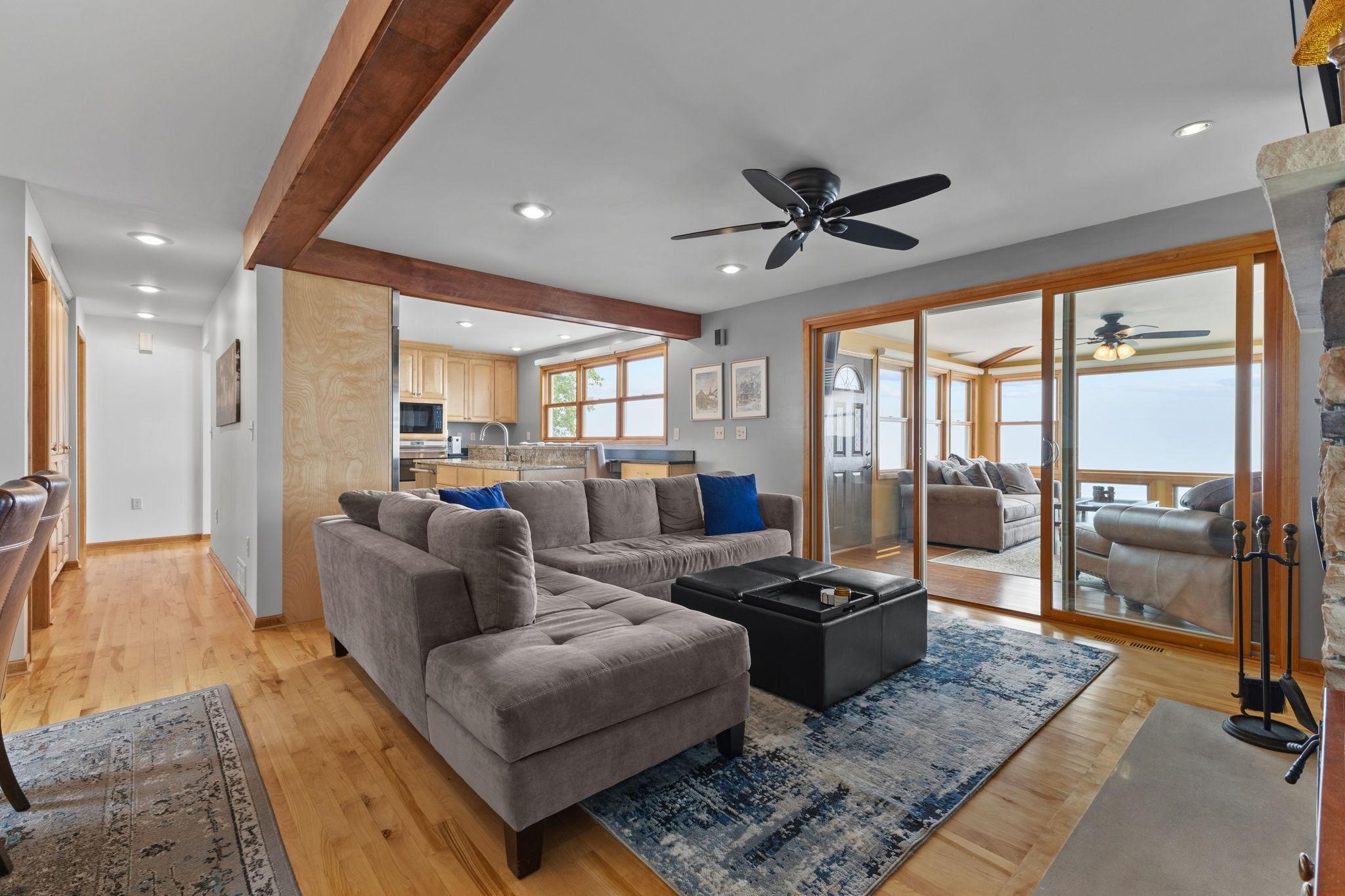 The open-concept great room flows seamlessly into the four-season sunroom, creating an exceptional space for entertaining while showcasing breathtaking views of the lake.