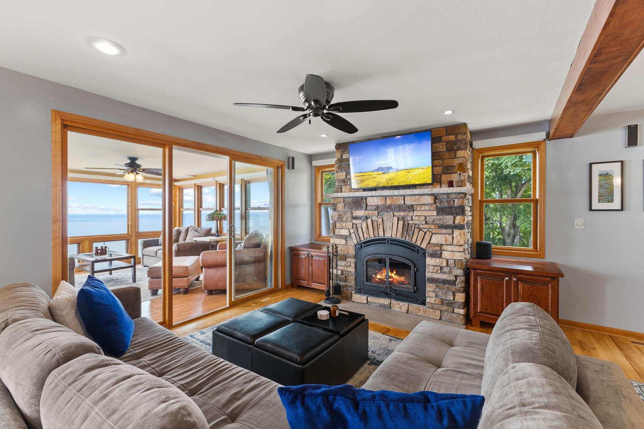 The great room is anchored by a floor-to-ceiling stone fireplace with a wood-burning insert and opens directly to the four-season sunroom, where breathtaking views of Lake Mille Lacs await.
