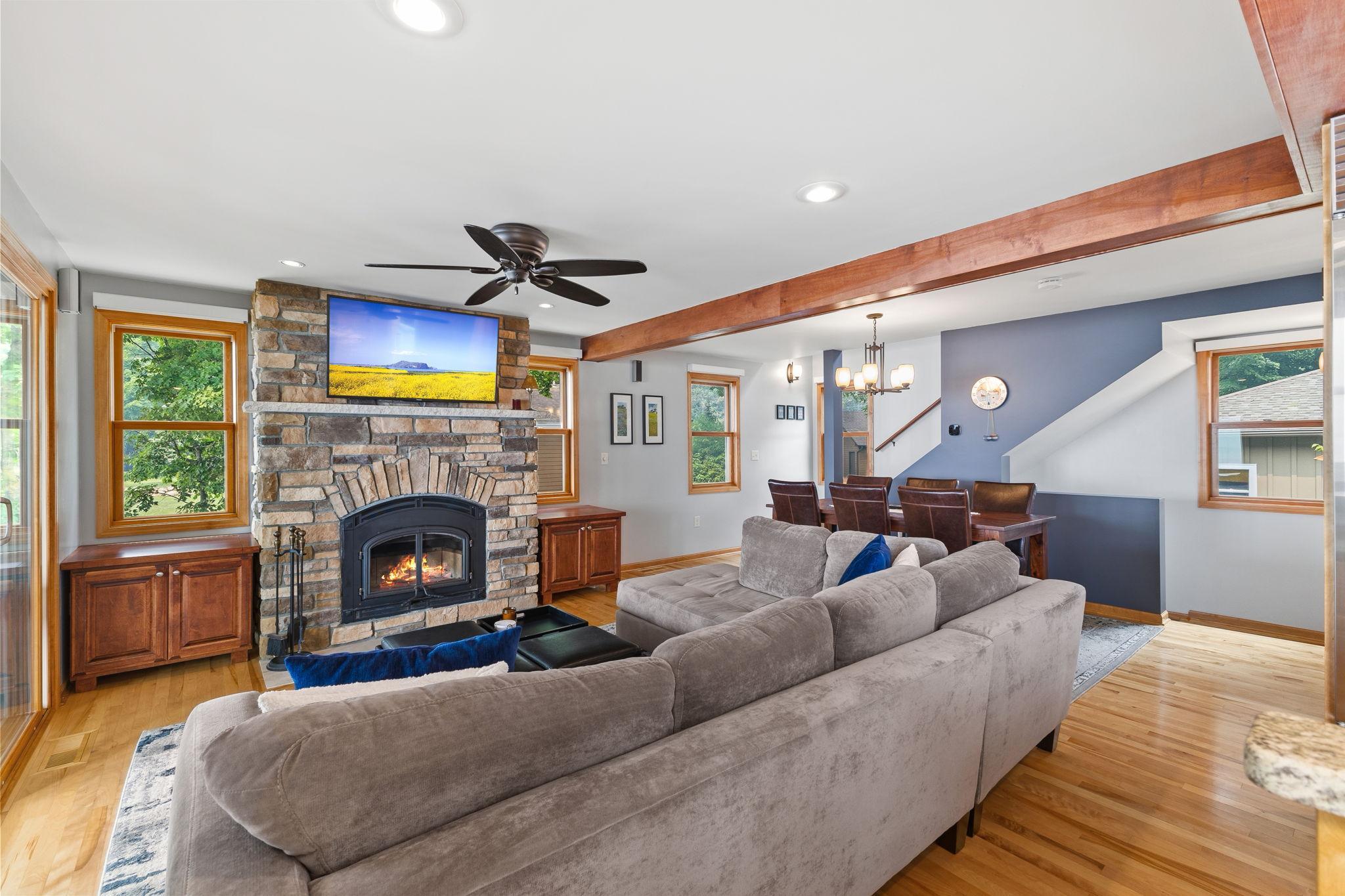 A dramatic floor-to-ceiling stone fireplace with a wood-burning insert anchors the great room, while the open design creates an ideal space for entertaining and everyday lake living.