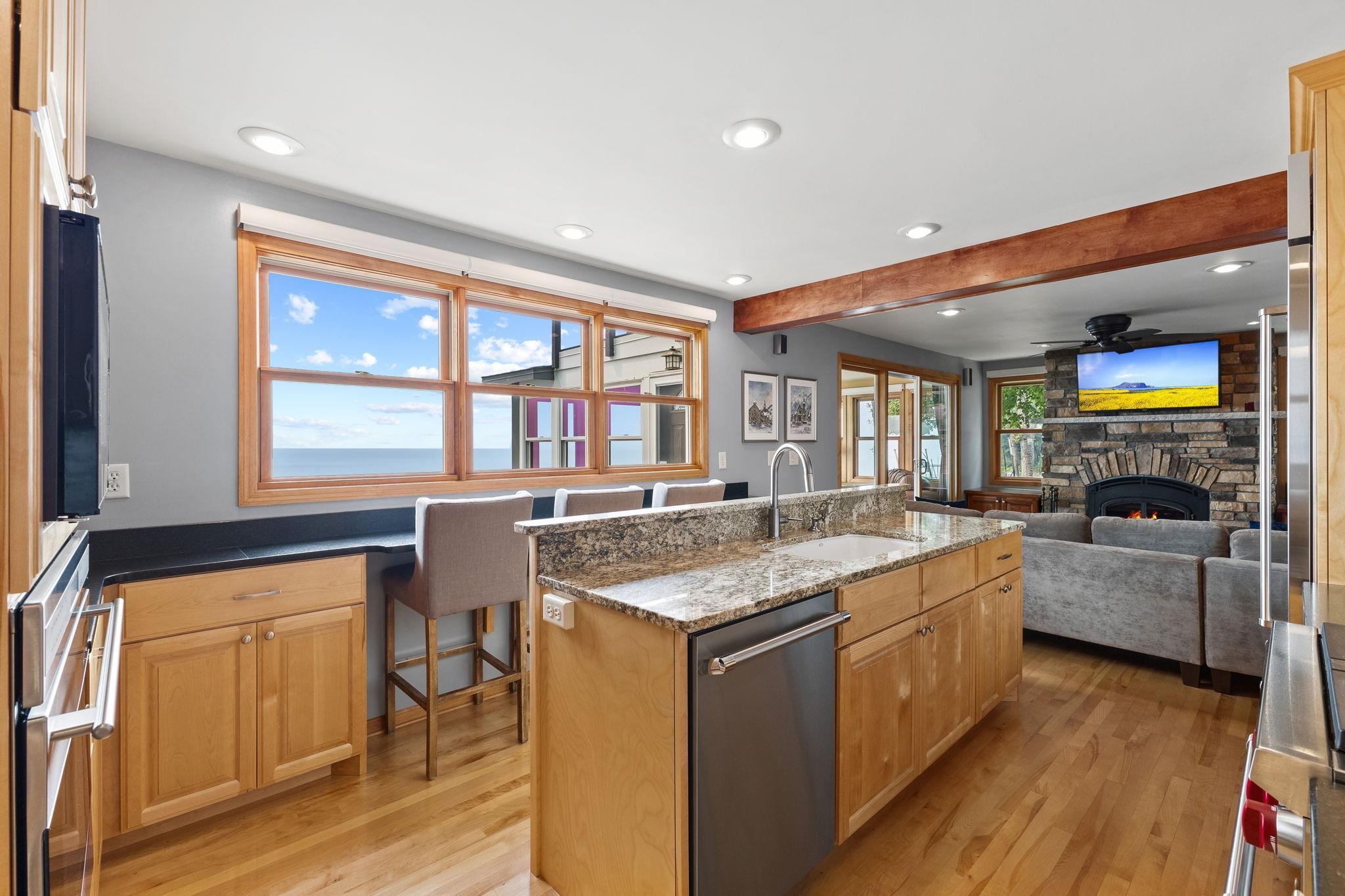 Enjoy lake views while cooking in the beautifully appointed kitchen with granite countertops, a spacious center island, breakfast bar seating, and an open layout perfect for entertaining.