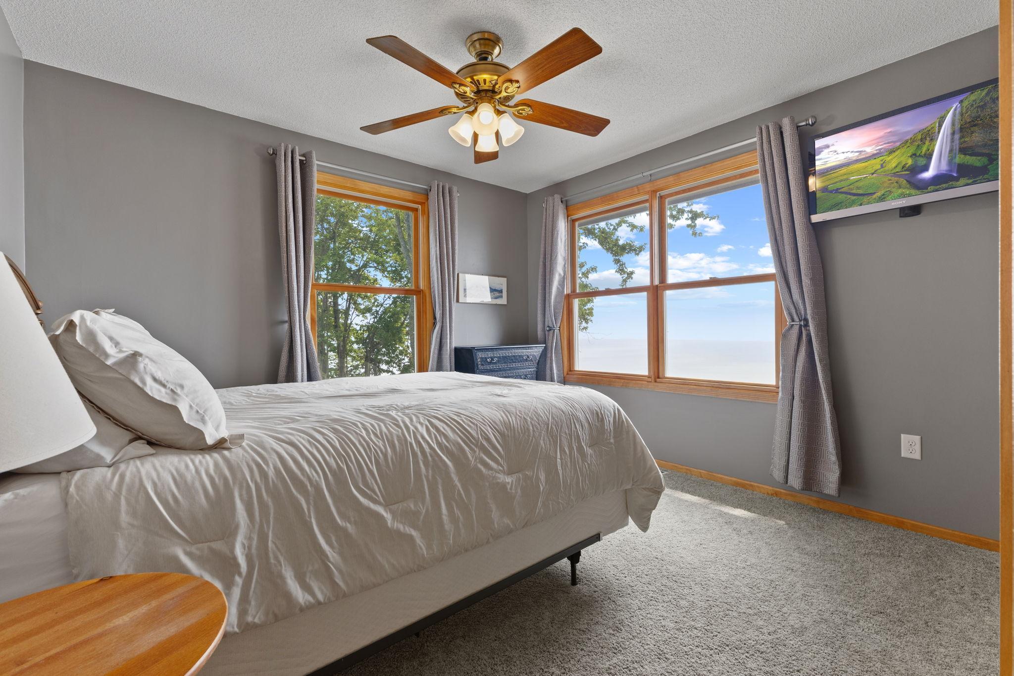 Offering scenic lake views and generous natural light, this inviting guest bedroom provides a comfortable place to relax