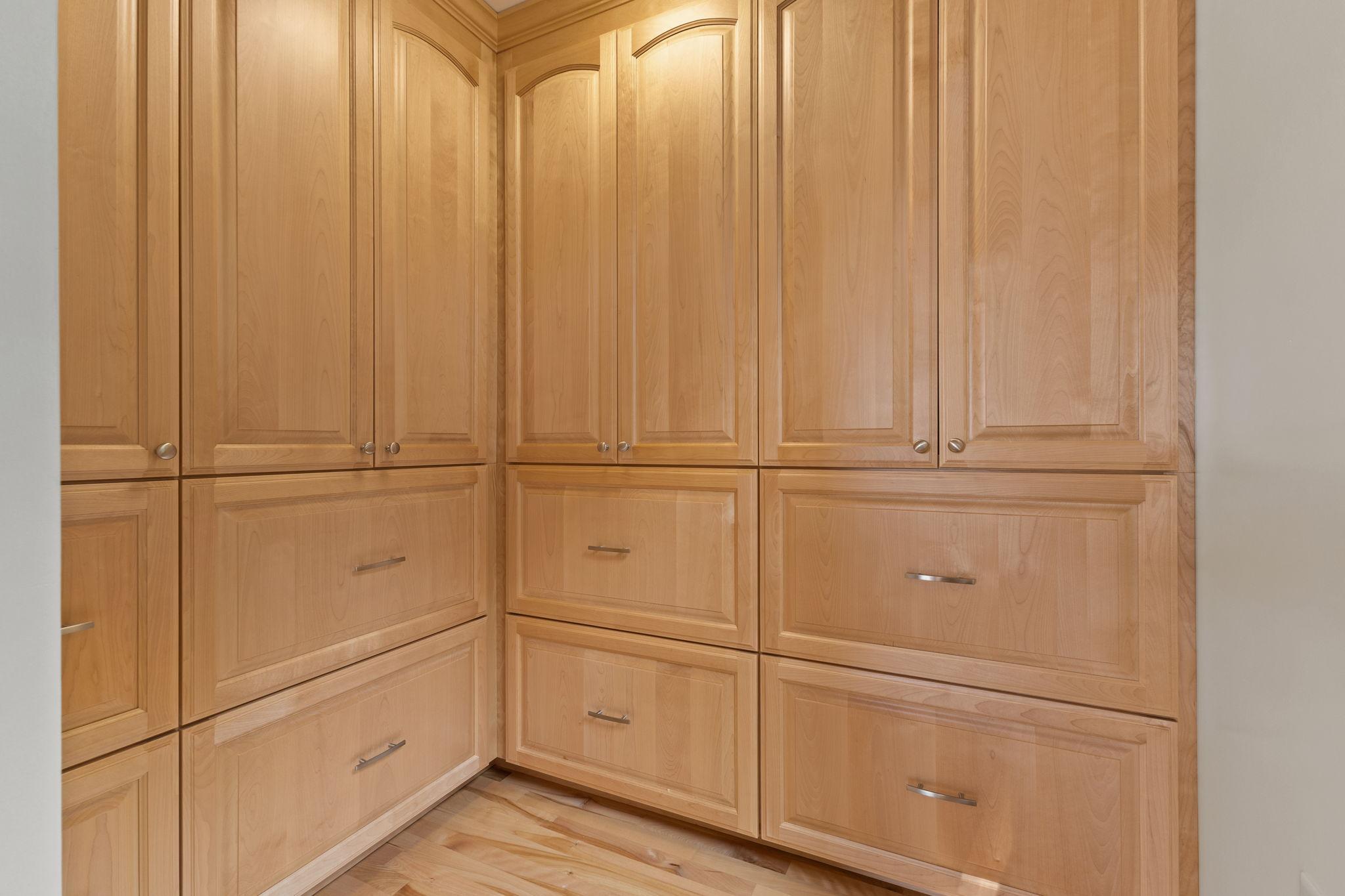 Exceptional storage is found throughout the home, including this dedicated space featuring floor-to-ceiling custom maple cabinetry and deep storage drawers.