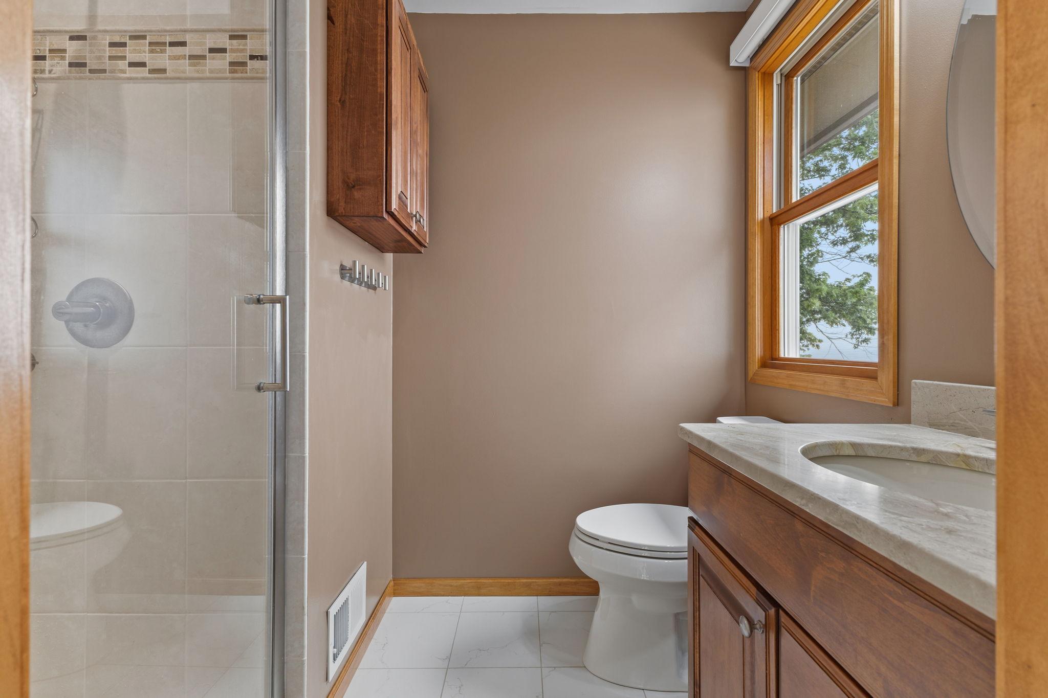 The private 3/4 owner's bath features a floor-to-ceiling tiled shower, quality finishes, creating a refined and comfortable retreat.