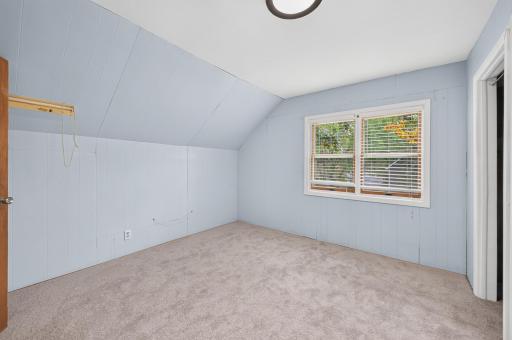 Second upper-level bedroom with plush carpeting and soft neutral tones.