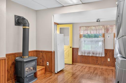 Large mudroom and laundry area features a gas-burning stove and convenient backyard access.