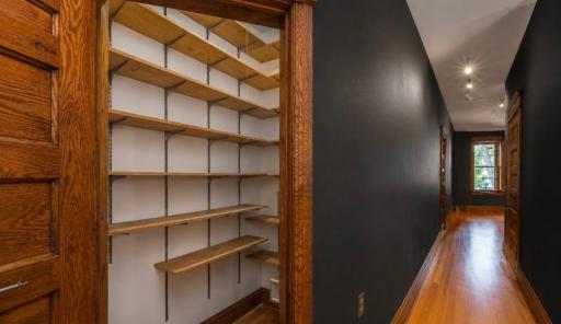 A large 4’ x 5’ walk-in pantry with abundant shelving lies off the hall.