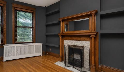 The fireplace has beautifully-carved wood and a period mirror with carved columns.