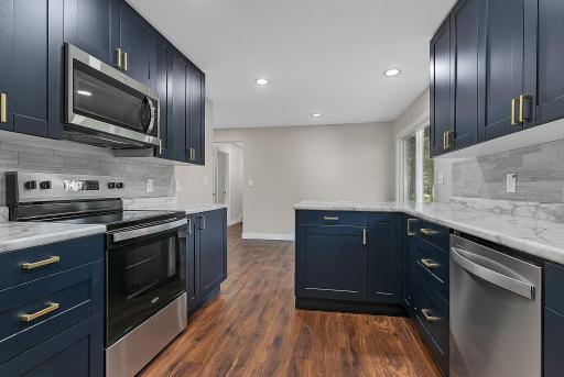 The eat-in kitchen features a full suite of brand new S.S. appliances including an electric range, dishwasher, refrigerator, and a microwave.