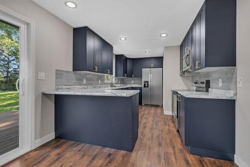 The updated kitchen features new laminate countertops, Klearvue cabinets, a window above the sink, and a dedicated pantry closet.