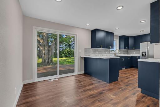 Durable LVP flooring is featured throughout the dining area and kitchen. A patio door leads out to the deck in the backyard.
