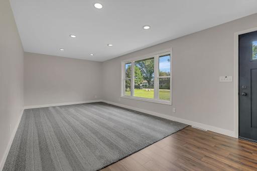The spacious living room features a large picture window to let in tons of natural light, as well as modern recessed canister lighting.