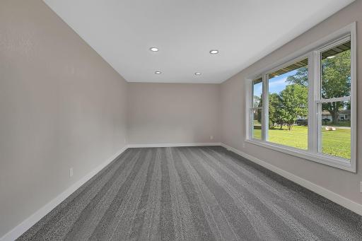 The spacious living room features a large picture window to let in tons of natural light, as well as modern recessed canister lighting.