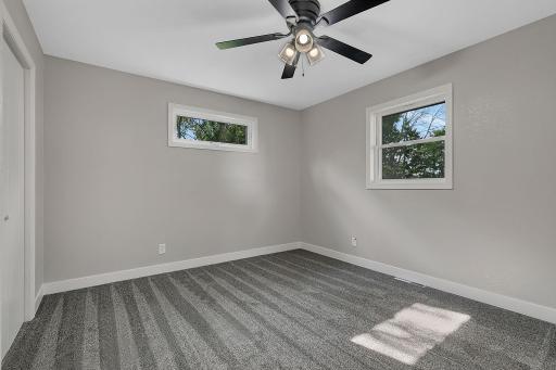 The primary bedroom features a ceiling fan. A private primary ensuite bathroom is featured. All three bedrooms feature brand new carpet, trim, and paint.