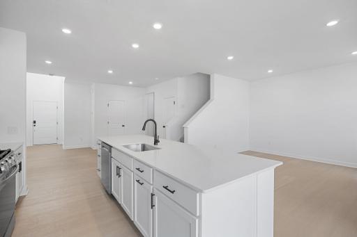 The multifunctional center island features an undermount stainless steel sink and a multi-cycle dishwasher