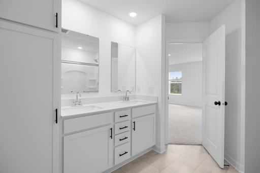 Quartz countertops, MoenÂ® Glyde faucets and dual sinks come together at this impressive vanity