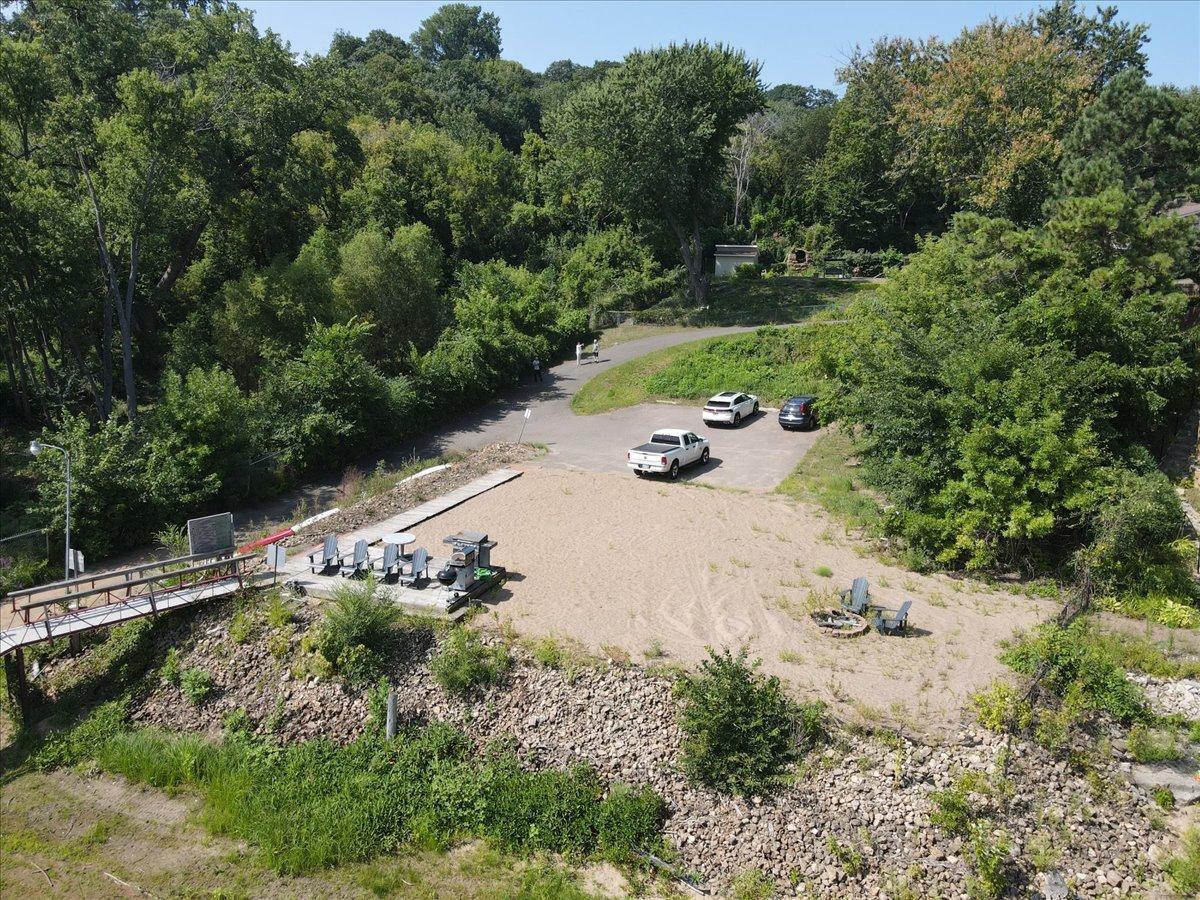 Convenient parking lot and sandy recreation space that includes a firepit and deck area for grilling.