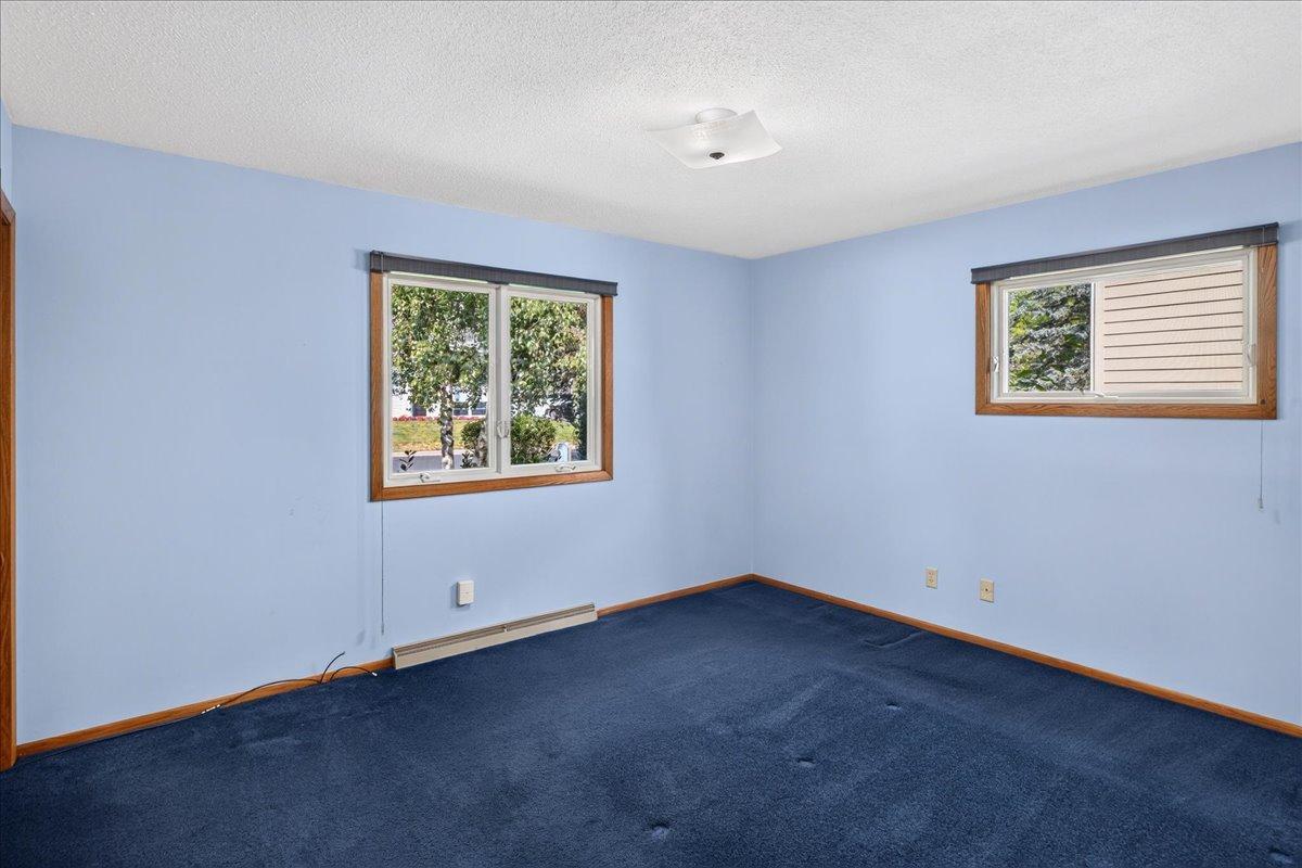 One of two main level bedrooms with windows to the front and side of home.