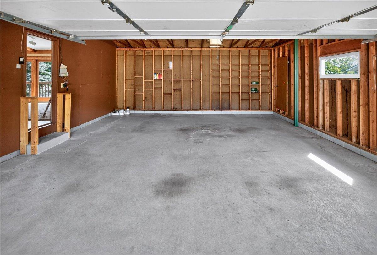 Oversized attached garage offers shelves for storage and a service door to the front walk and driveway.