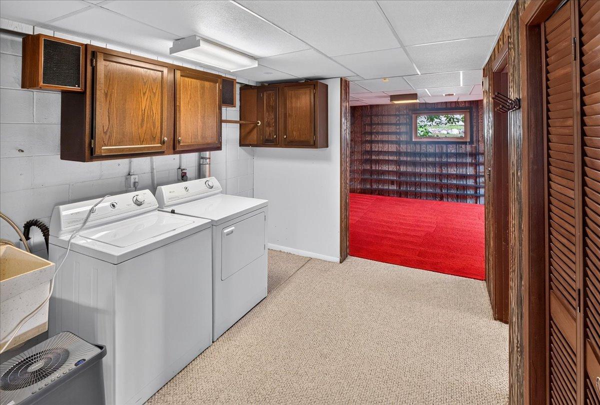 Laundry room in the lower level offers storage cabinets and a utility sink. Bifold door conceal the mechanicals.