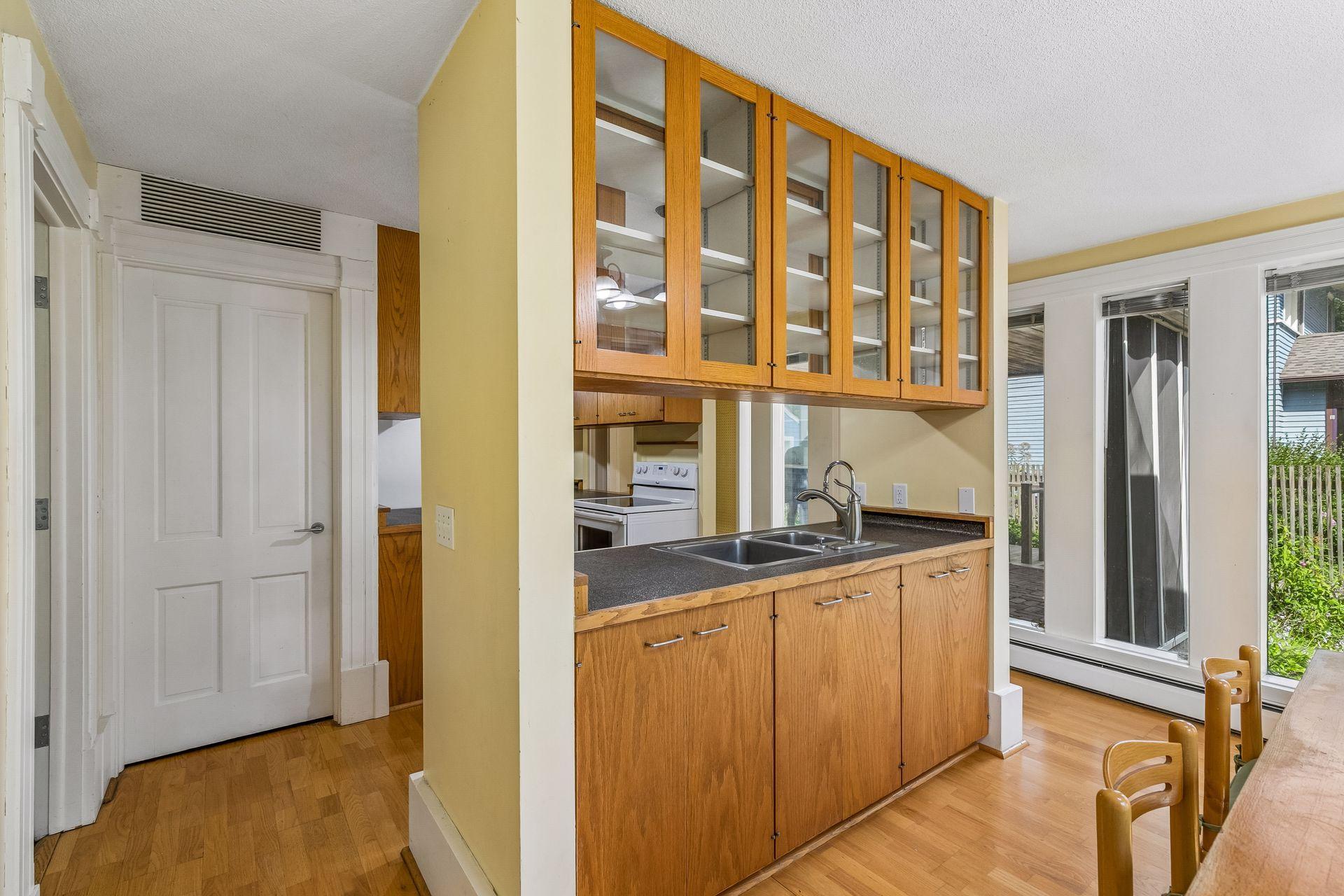 Bright and airy kitchen. Note hardwood floors.