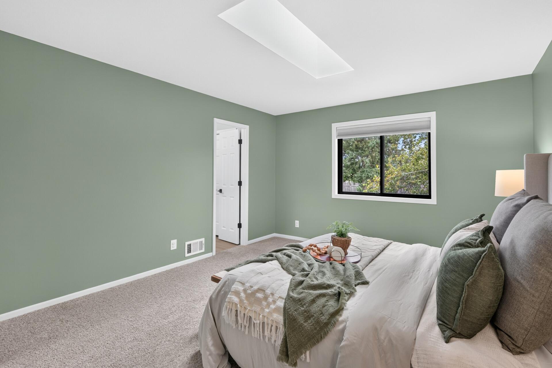 Primary bedroom with skylight and overlooks the backyard