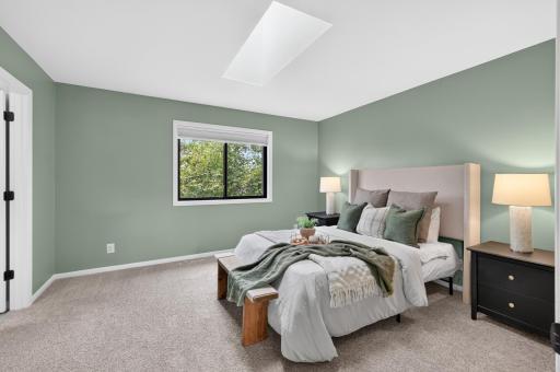 Primary bedroom with skylight and overlooks the backyard