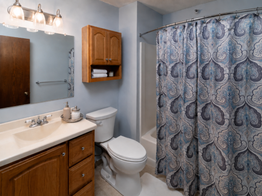 Full bathroom with tub and shower combination, vanity storage, and additional wall-mounted cabinetry. *Virtually staged for inspiration*