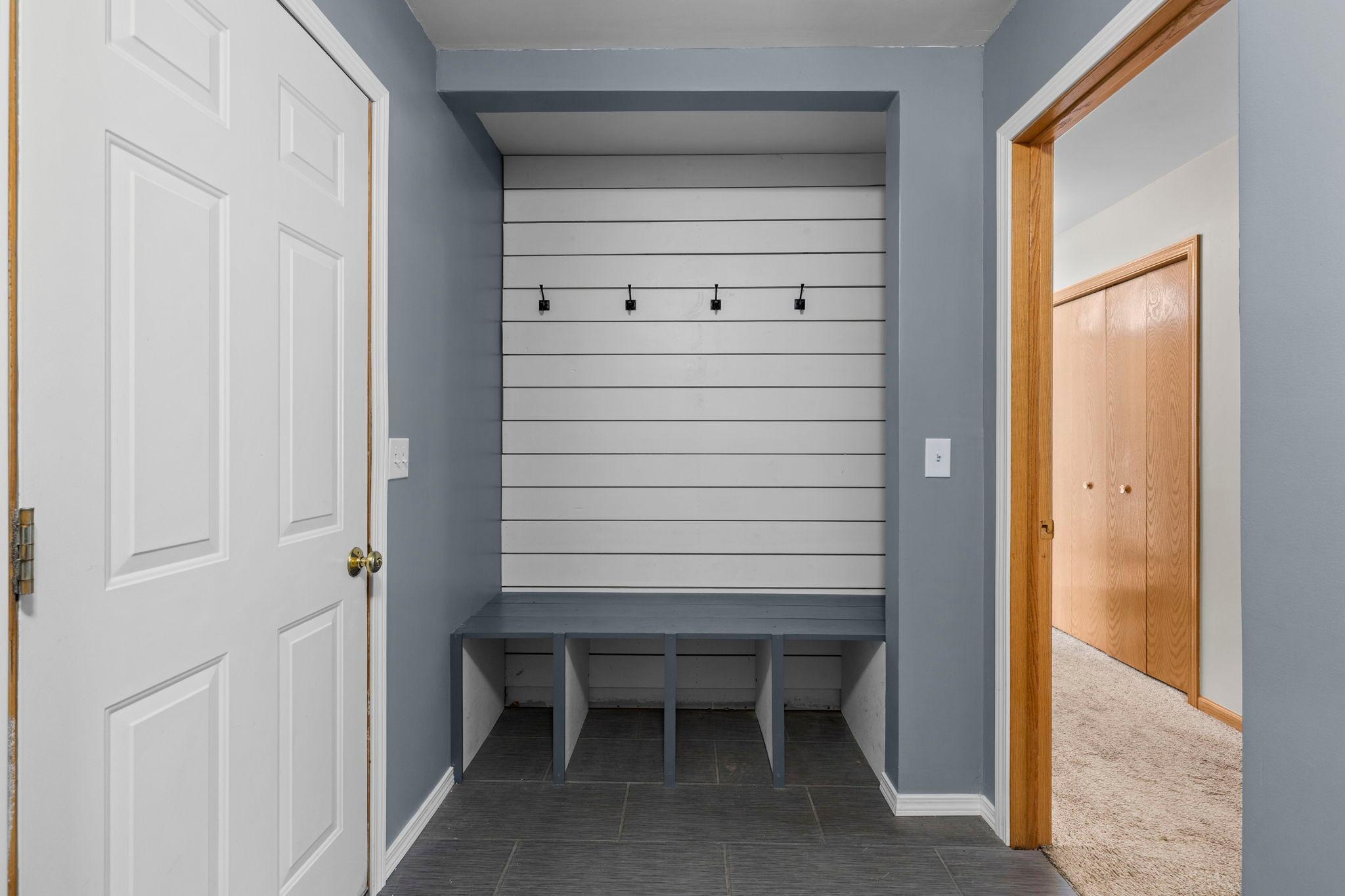 A convenient built-in drop zone helps keep coats, bags, shoes, and everyday essentials organized in the mudroom