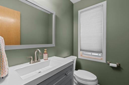 The updated main-floor half bath features a fresh, modern vanity and is conveniently located for guests