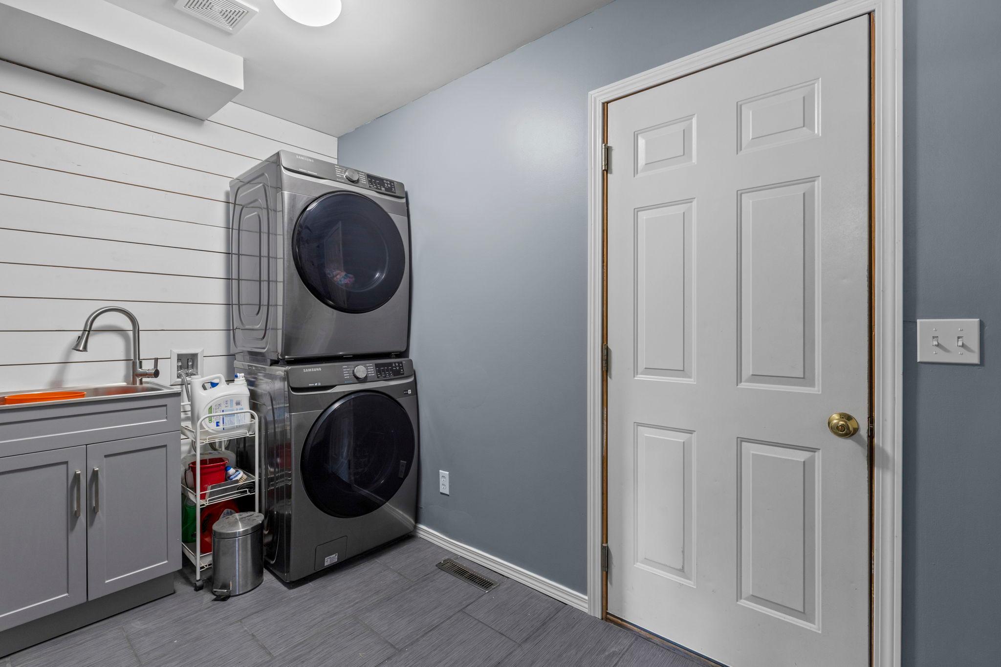 The remodeled main-floor laundry room offers a practical everyday workspace with newer washer and dryer