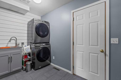 The remodeled main-floor laundry room offers a practical everyday workspace with newer washer and dryer
