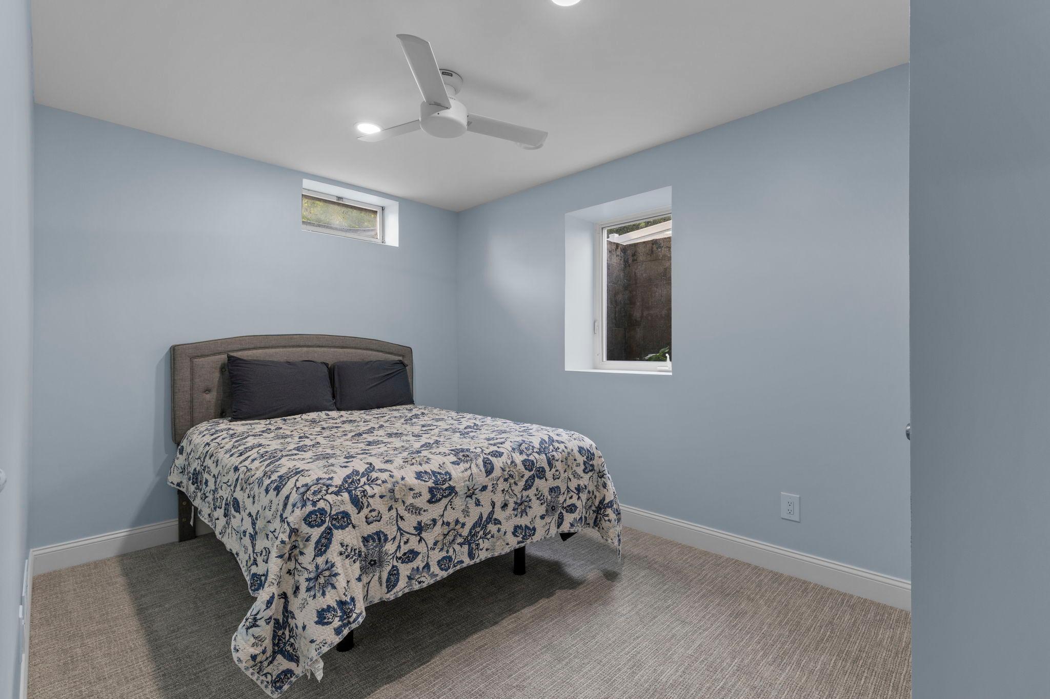 Lower level bedroom 5 features a new egress window, ceiling fan, and comfortable living space