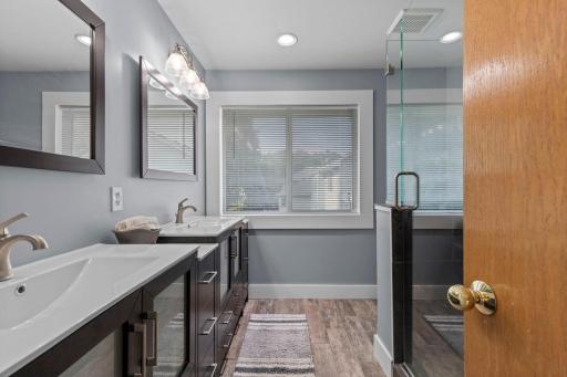 Beautifully remodeled primary bath featuring dual vanities, updated finishes, and a clean, modern look