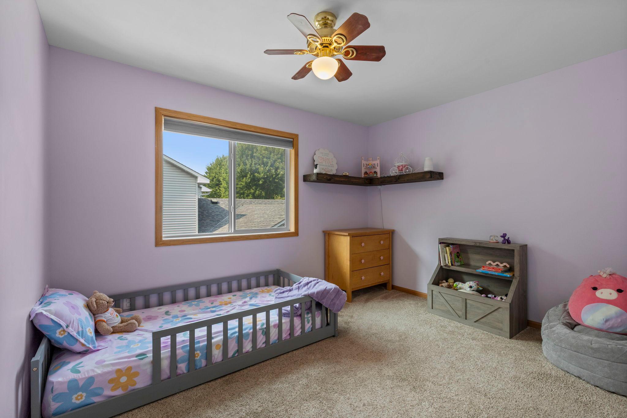 Comfortable upper-level bedroom 2 with a large window, ceiling fan, and plenty of room to make the space your own