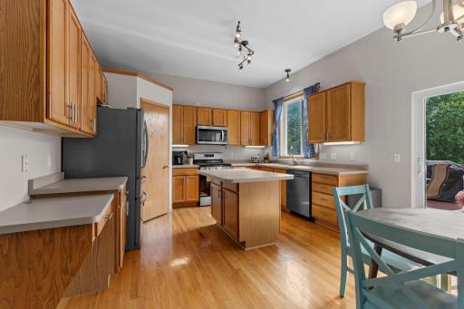 Kitchen features generous cabinet and counter space, center island, and hardwood flooring