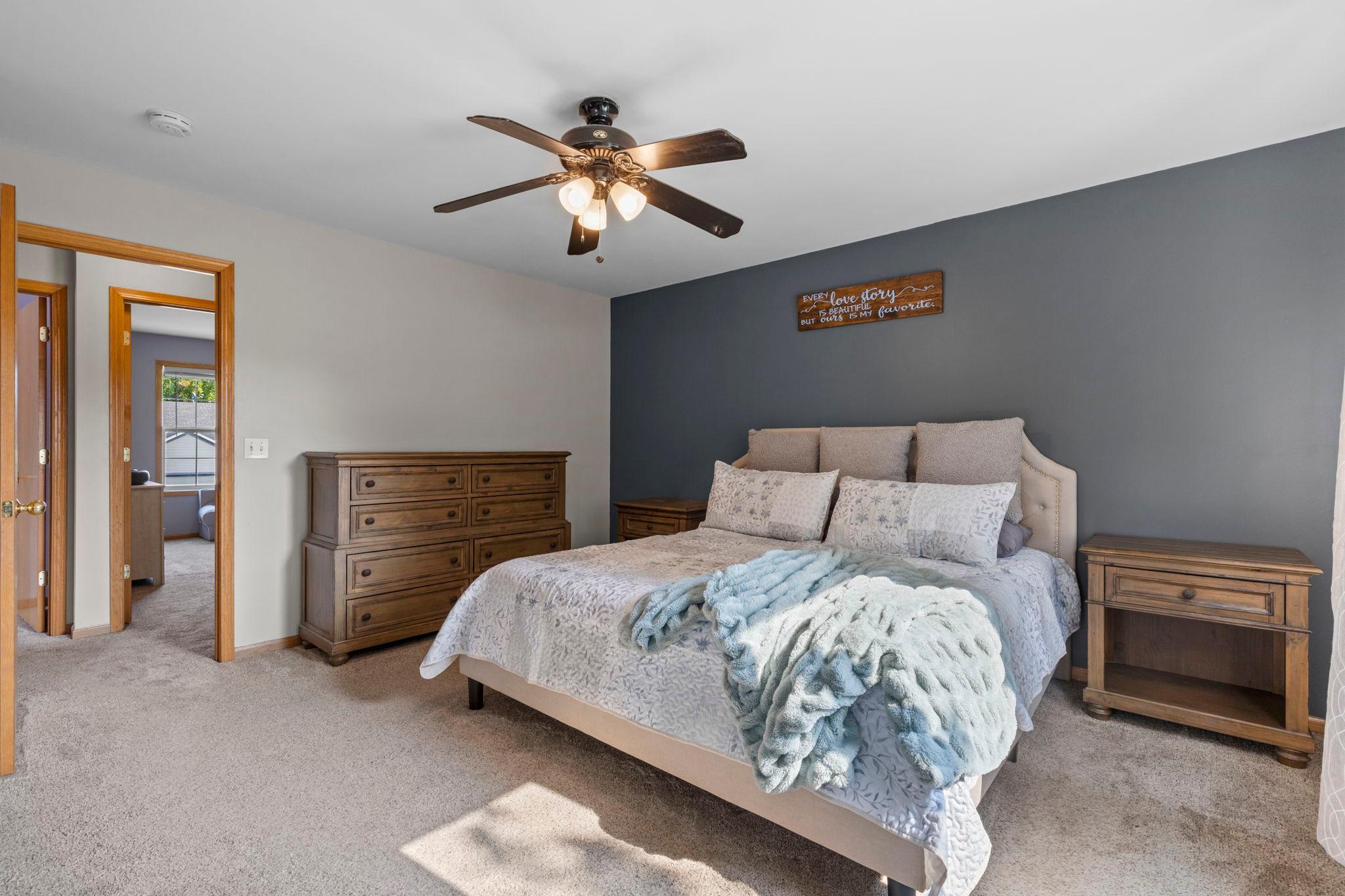 Another view of the primary suite, complete with a ceiling fan and private remodeled bath
