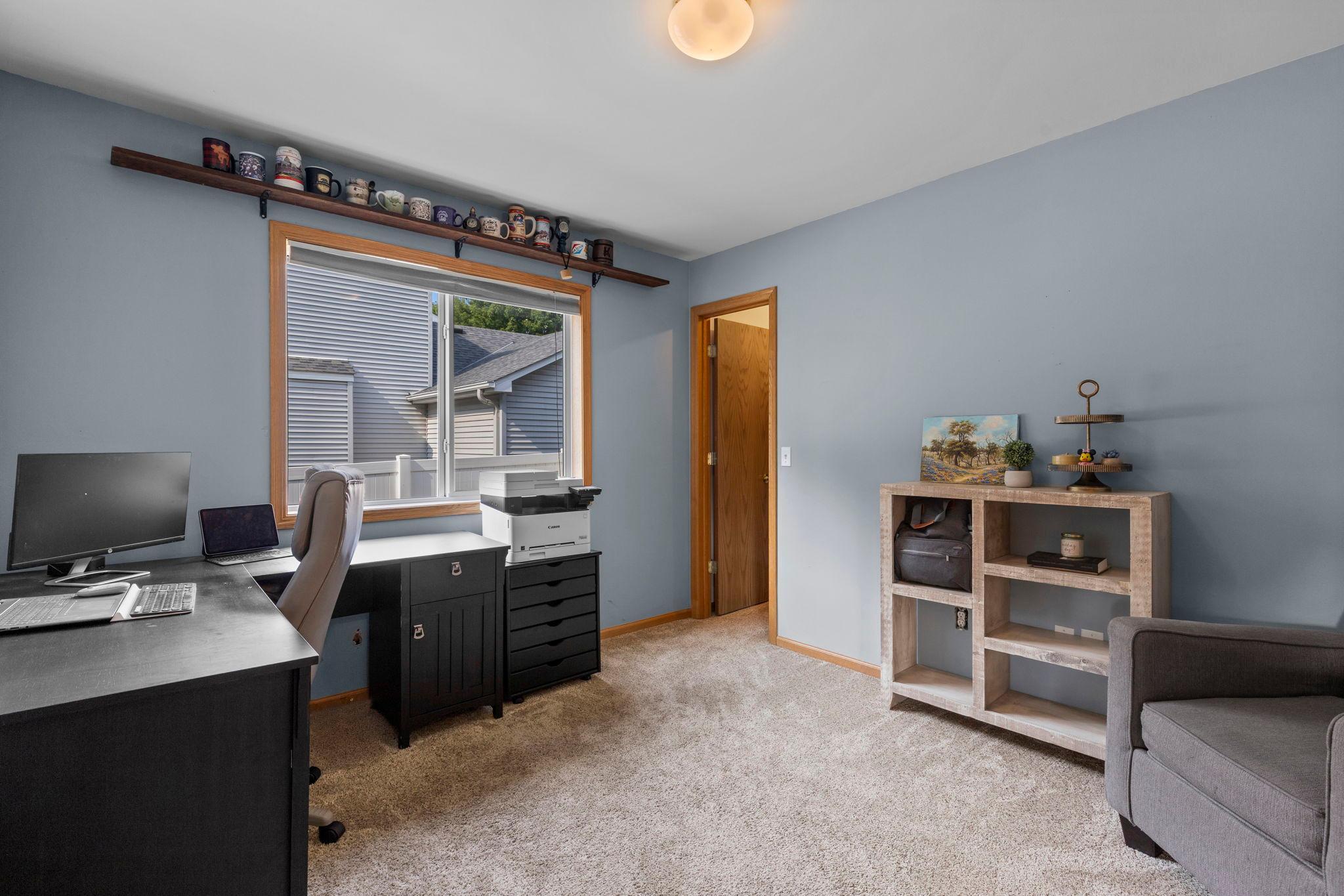 Bright and comfortable, the main-level bedroom features a large window and plenty of space to easily function as a home office