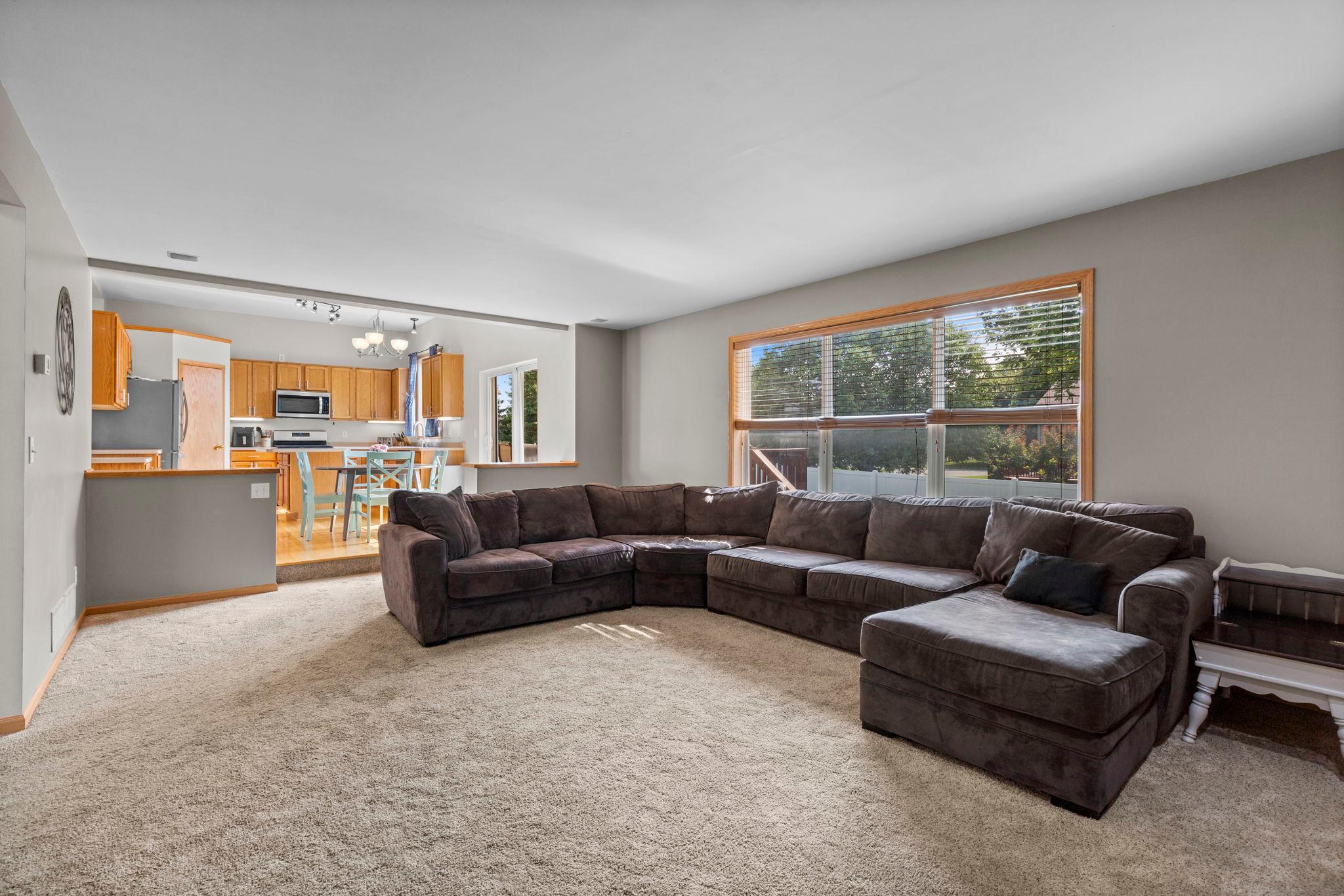 The family room offers plenty of space to spread out, with a large window bringing in natural light and an easy connection to the kitchen