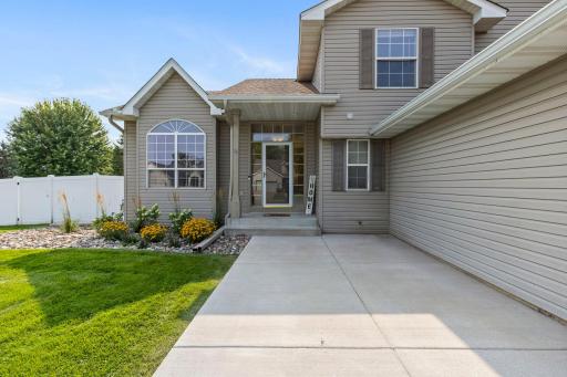 A warm welcome begins at the front door, surrounded by beautifully refreshed landscaping and a spacious front patio