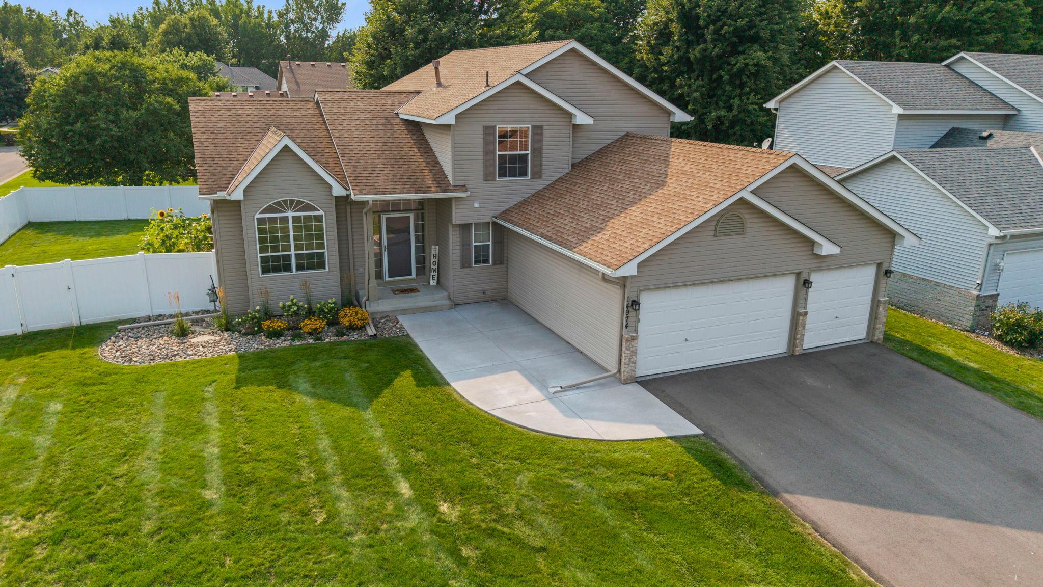 Welcoming exterior with fresh front landscaping, a new concrete walkway/patio, and new asphalt driveway