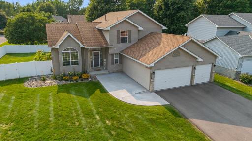 Welcoming exterior with fresh front landscaping, a new concrete walkway/patio, and new asphalt driveway